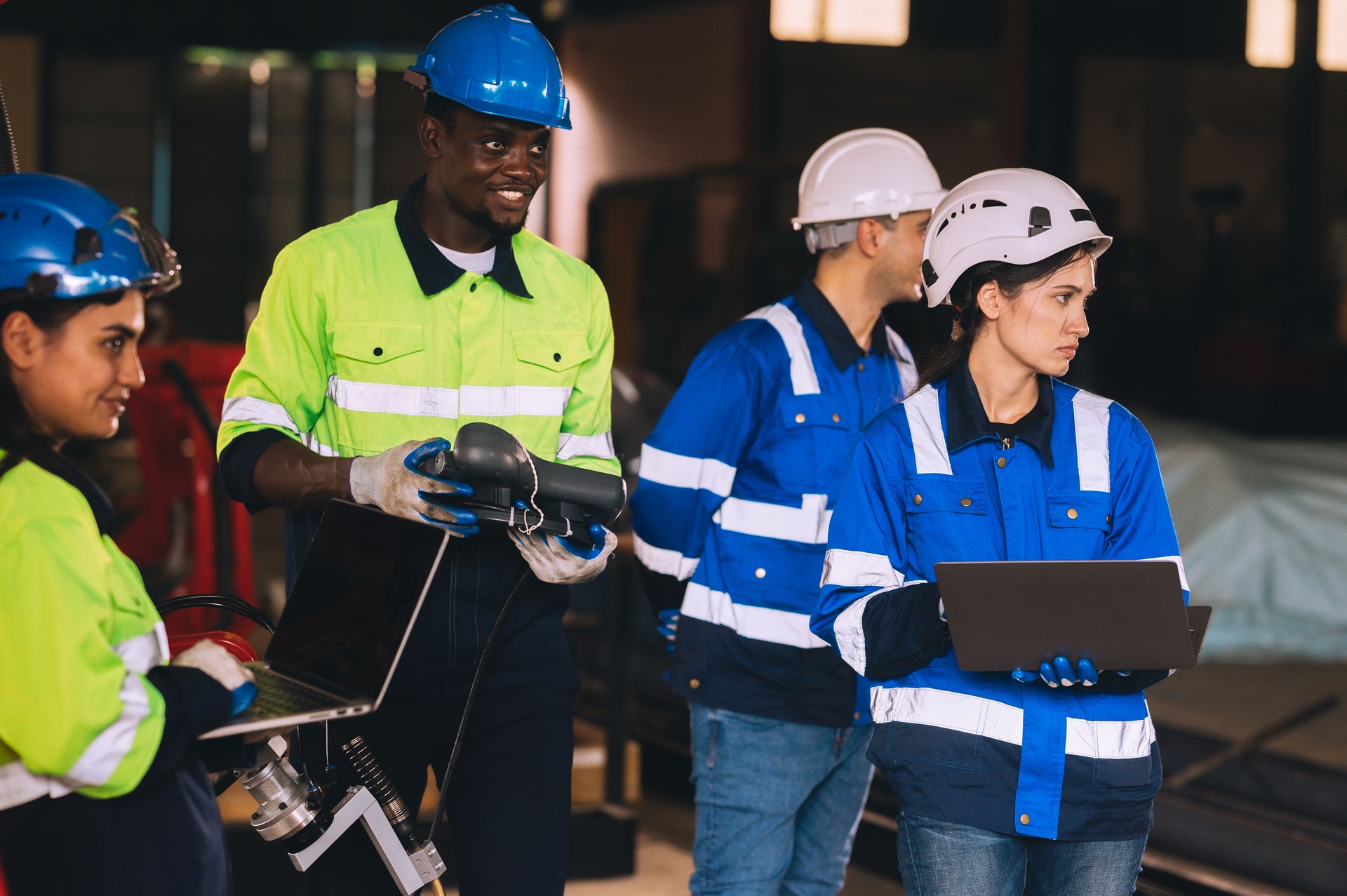 Female engineers work as a team training together in a modern technology world advanced robot welding machine factory.